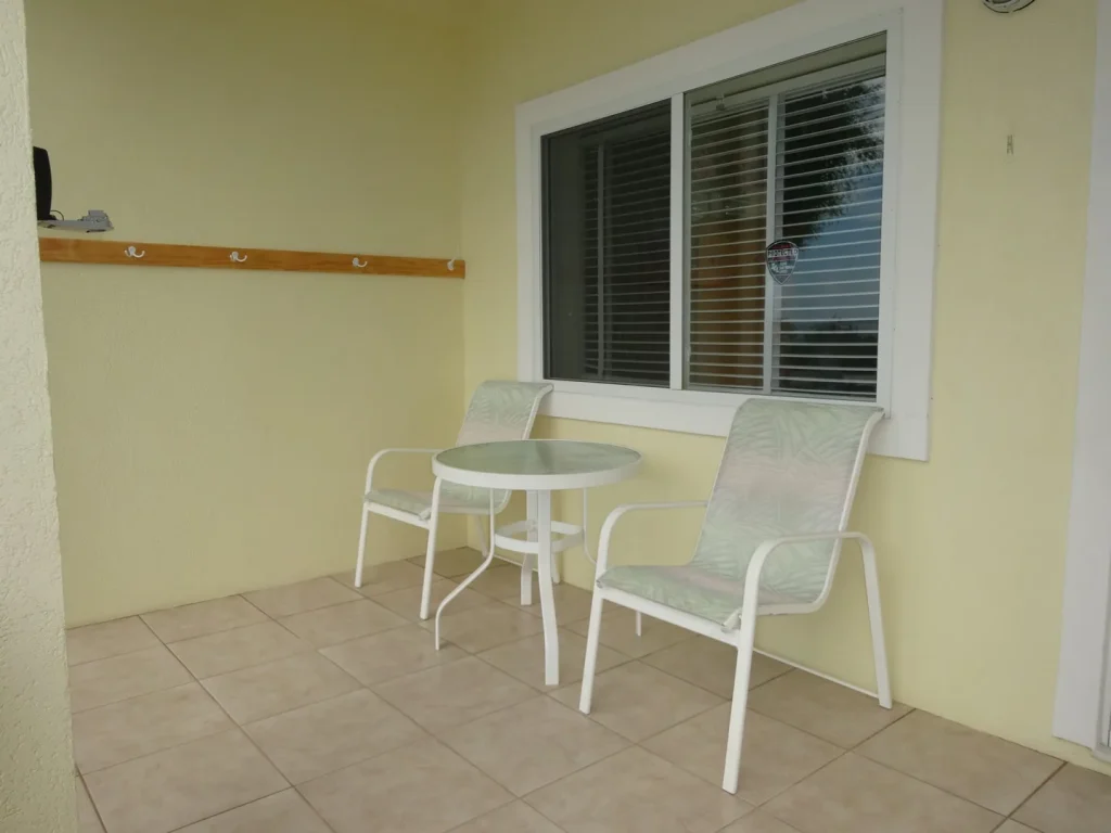 Covered terrace with table and chairs at Sunset Paradise 1