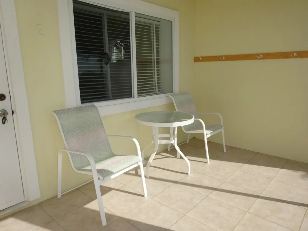 Covered terrace with table and chairs at Sunset Paradise 2